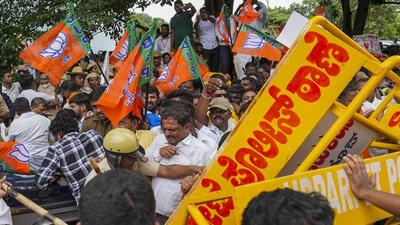 Police personnel stop BJP workers trying to climb barricades during a protest demanding the resignation of Chief Minister Siddaramaiah over the alleged scam in the Karnataka Maharshi Valmiki Scheduled Tribes Development Corporation Ltd., in Bengaluru on Thursday. (PTI) Police personnel stop BJP workers trying to climb barricades during a protest demanding the resignation of Chief Minister Siddaramaiah over the alleged scam in the Karnataka Maharshi Valmiki Scheduled Tribes Development Corporation Ltd., in Bengaluru on Thursday. (PTI)