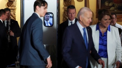 U.S. President Joe Biden greets people, as a Secret Service agent watches through the kitchen door's window, at Lindo Michoacan Mexican Restaurant, in Las Vegas, Nevada. (REUTERS)
