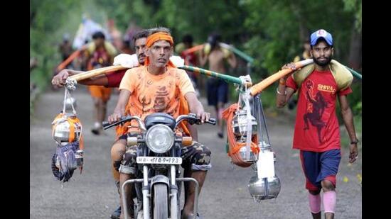 Kanwariyas seen on their way to Okhla Bird Sanctuary while coming back from Haridwar carrying water from the Ganga River, in Noida on July 28, 2019. (HT File)