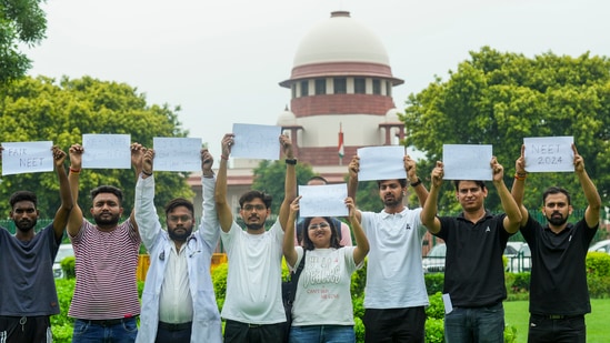 Students display placards in the precinct of the Supreme Court during a hearing on the NEET paper leak case, in New Delhi. (PTI)
