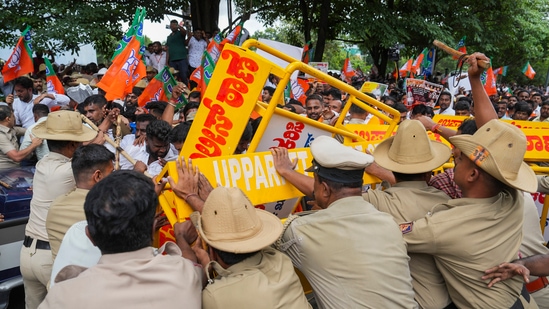 Police personnel stop BJP workers protesting over the alleged scam in the Karnataka Maharshi Valmiki Scheduled Tribes Development Corporation.(PTI)