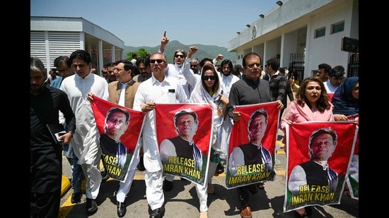 TOPSHOT - Parliamentarians of the Pakistan Tehreek-e-Insaf (PTI) party, carry posters of jailed former prime minister Imran Khan, during a protest outside the Parliament house in Islamabad on July 18, 2024. Photo by Aamir QURESHI / AFP) (AFP)