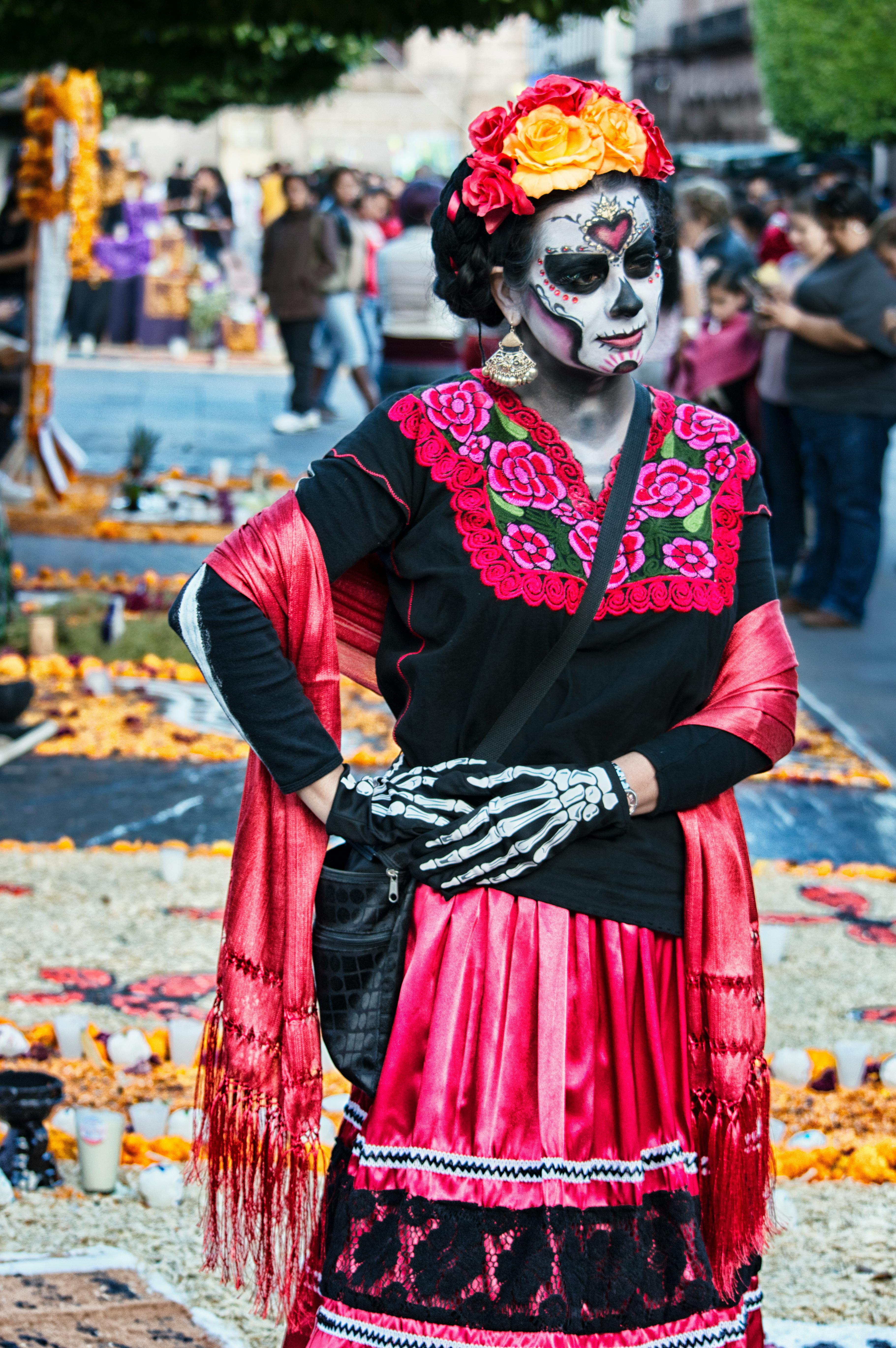 People wear traditional dresses, and flowery headgear and paint their faces.