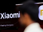 A man walks past a logo of Xiaomi, a Chinese manufacturer of consumer electronics, outside a shop in Mumbai, Chinese brands dominate as total shipments grow by 1%, says Canalys.