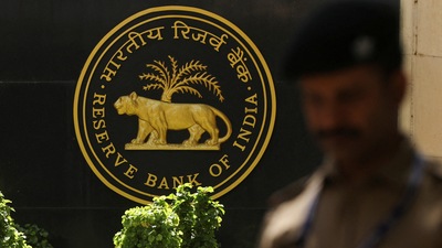 A police officer walks past the Reserve Bank of India (RBI) logo inside its headquarters in Mumbai, India. (Reuters)