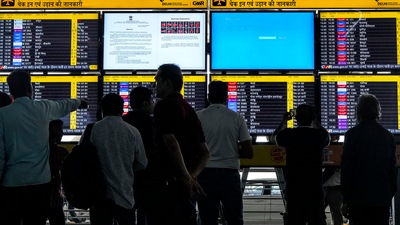 Passengers look at screens, some of them showing Blue Screen errors, at T3 Terminal of the Indira Gandhi International Airport amid Microsoft outage, in New Delhi, Friday, July 19, 2024. (PTI)