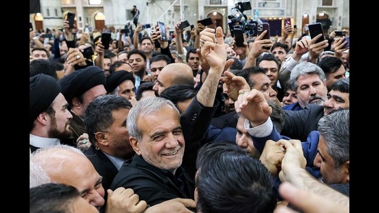 Iran's newly-elected President Masoud Pezeshkian (C) waves to supporters as he visits the shrine of the Islamic Republic's founder Ayatollah Ruhollah Khomeini in Tehran on July 6, 2024. (Photo by ATTA KENARE / AFP) (AFP)