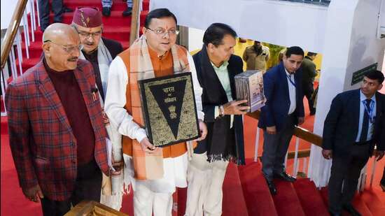 Uttarakhand Chief Minister Pushkar Singh Dhami with others holds a copy of the Constitution of India, at Vidhan Sabha Bhawan, in Dehradun, Tuesday, Feb. 6, 2024 (PTI)