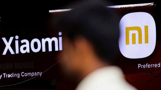 A man walks past a logo of Xiaomi, a Chinese manufacturer of consumer electronics, outside a shop in Mumbai, Chinese brands dominate as total shipments grow by 1%, says Canalys.(Reuters)