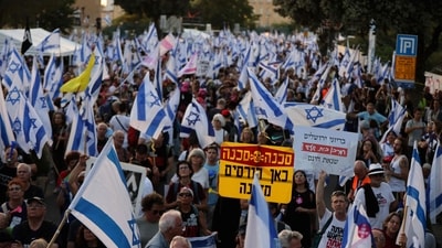 Israelis waving their national flag gather during an anti-government rally calling for early elections, outside the Knesset or Israeli Parliament in Jerusalem on June 18, 2024, amid the ongoing conflict in the Gaza Strip between Israel and the Palestinian militant Hamas movement. (Photo by Menahem KAHANA / AFP) (AFP)