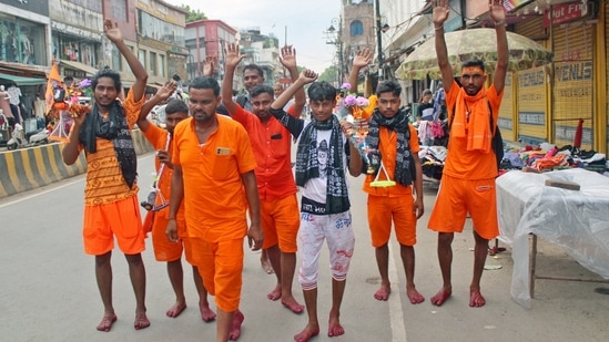 Varanasi, Jul 19 (ANI): Kanwariyas (Shiva devotees) carrying metal pots filled with water from the River Ganga during their annual Kanwar Yatra, in Varanasi on Friday. (ANI Photo)(Rajesh Journalist)