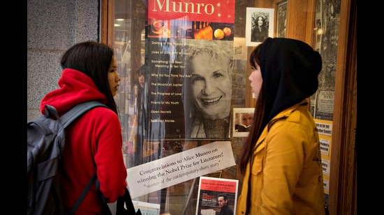 FILE PHOTO: Customers look at a window display congratulating Canadian author Alice Munro at bookstore Munro's Books after she won the Nobel Prize for Literature in Victoria, British Columbia October 10, 2013. REUTERS/Andy Clark/File Photo (REUTERS)