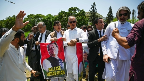 Parliamentarians of the Pakistan Tehreek-e-Insaf (PTI) party, carry posters of jailed former prime minister Imran Khan, during a protest outside the Parliament house in Islamabad on July 18, 2024. (Photo by Aamir QURESHI / AFP)(AFP)