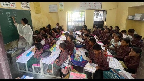 Students sitting in a single room, despite hot and humid weather condition, at Government Primary Smart School, Kundanpuri, due to lack of space in Ludhiana on Saturday. (Manish/Hindustan Times)