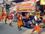 Muzaffarnagar: Kanwariyas walk past the shops on which banners with shopkeepers' names were put up on Kanwar Marg after an order issued by the Uttar Pradesh government. Muzaffarnagar: Kanwariyas walk past the shops on which banners with shopkeepers' names were put up on Kanwar Marg after an order issued by the Uttar Pradesh government.