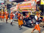 Muzaffarnagar: Kanwariyas walk past the shops on which banners with shopkeepers' name were put up on Kanwar Marg after an order issued by Uttar Pradesh Government, in Muzaffarnagar, Saturday, July 20, 2024. (PTI Photo) (PTI07_20_2024_000145A)(PTI)