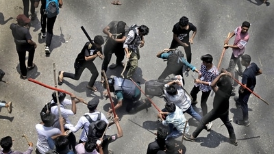 Students beat a policeman with sticks during a protest over the quota system in public service in Dhaka, Bangladesh, Thursday July 18, 2024. (AP)