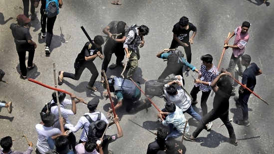 Students beat a policeman with sticks during a protest over the quota system in public service in Dhaka, Bangladesh, Thursday July 18, 2024.(AP)