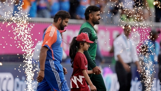 Pakistan's captain Babar Azam, right, and India's captain Rohit Sharma walk into the field.(PTI)