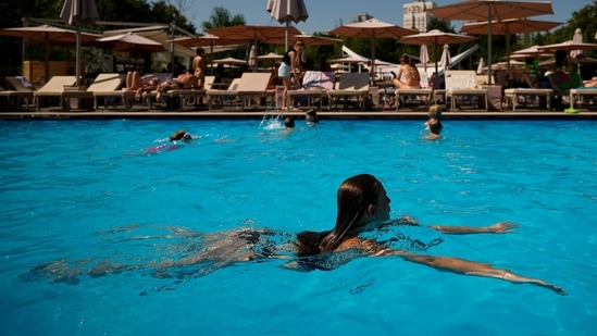 A woman swims in a public swimming pool to cool off in the summer. (AP)