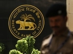 A police officer walks past the Reserve Bank of India (RBI) logo inside its headquarters in Mumbai, India.(Reuters)