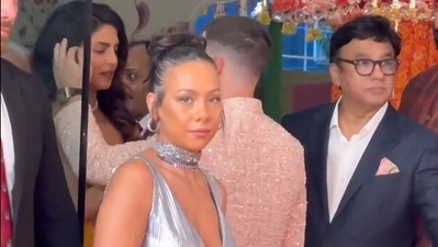 Mona Kattan's stylist standing in front of Priyanka Chopra and Nick Jonas at Ambani wedding. 