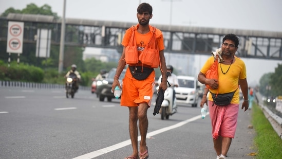 Devotees carrying holy water collected from River Ganga in Haridwar going back to their home during the Kanwar Yatra at National Highway-48 in Gurugram. (Parveen Kumar/Hindustan Times)
