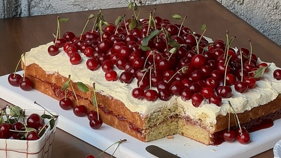 A vanilla sheet cake with buttercream and topped with cherries (Instagram)