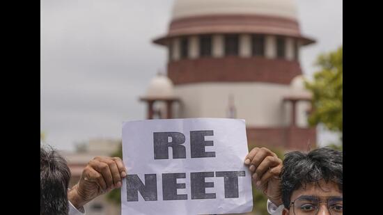 A student holds a placard demanding re-examination of NEET at the premises of the Supreme Court of India, in New Delhi on Monday. (PTI) A student holds a placard demanding re-examination of NEET at the premises of the Supreme Court of India, in New Delhi on Monday. (PTI)