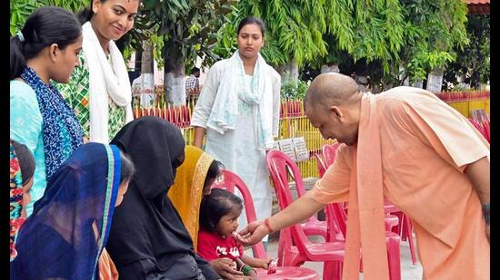 Chief minister Yogi Adityanath embraces a child during Janata Darshan at Gorakhnath Temple premises in Gorakhpur on Monday. (ANI Photo)