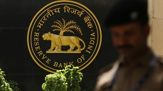 A police officer walks past the Reserve Bank of India (RBI) logo inside its headquarters in Mumbai, India.(Reuters)