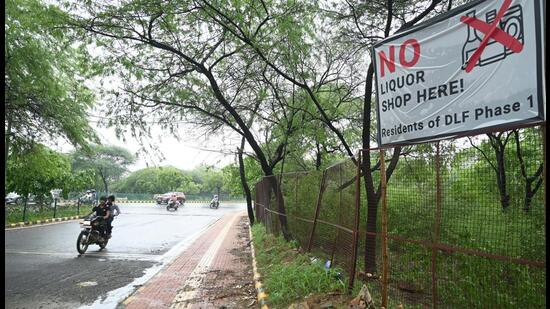 Residents of DLF phase-1 installed hoarding against the liquor shop opening at Khushboo chowk near Samadhaan Hub in Gurugram on Monday. (Parveen Kumar/HT)