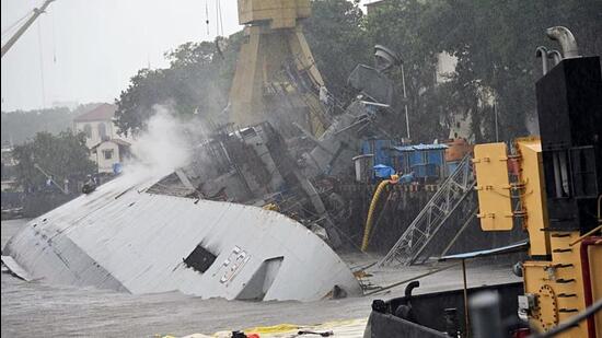 Indian Navy frigate INS Brahmaputra lies tilted to one side (port side) inside the Mumbai naval dockyard. (ANI Photo)