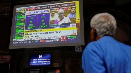 A man watches a screen displaying India's Finance Minister Nirmala Sitharaman's budget speech at a railway station in Mumbai, India, July 23, 2024.(REUTERS)