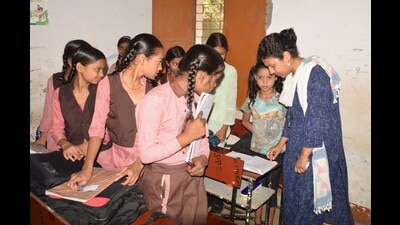 Kheri DM Durga Shakti Nagpal testing reading skills of basic school children at Aadha Chat village in Lakhimpur on Wednesday. (HT)