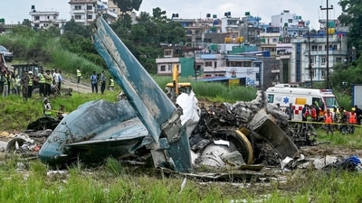 Security personnel inspect the remains of a Saurya Airlines flight after it crashed during takeoff at Tribhuvan International Airport in Kathmandu on July 24, (Photo by PRAKASH MATHEMA / AFP) (AFP) Security personnel inspect the remains of a Saurya Airlines flight after it crashed during takeoff at Tribhuvan International Airport in Kathmandu on July 24, (Photo by PRAKASH MATHEMA / AFP) (AFP)