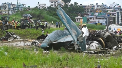Army personnel and other officials stand around the debris of a Saurya Airlines plane after it crashed during takeoff at Tribhuvan International Airport in Kathmandu on July 24, 2024. (AFP)