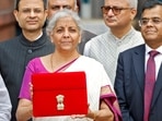 Finance minister Nirmala Sitharaman holds up a folder with the Government of India's logo as she leaves her office to present the union budget in the parliament in New Delhi. Finance minister Nirmala Sitharaman holds up a folder with the Government of India's logo as she leaves her office to present the union budget in the parliament in New Delhi.