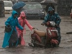 Children push their father's scooter through a flooded street as it rains in Mumbai, India, (AP Photo) Children push their father's scooter through a flooded street as it rains in Mumbai, India, (AP Photo)