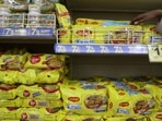 A worker arranges packets of Nestle's Maggi noodles on a shelf inside a supermarket in Mumbai, India.