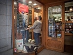 FILE PHOTO: An employee adjusts a poster of Canadian author Alice Munro in Munro's bookstore after she won the Nobel Prize for Literature in Victoria, British Columbia October 10, 2013. REUTERS/Andy Clark/File Photo