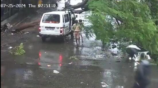 A giant tree fell on a school van and pillion rider in Anand Park, Wadgaon Sheri, around 8 am on Thursday morning. No casualties were reported, said officials. The fire brigade department swiftly responded and removed the tree that damaged the roof of the van. (HT PHOTO)