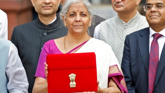 Finance minister Nirmala Sitharaman holds up a folder with the Government of India's logo as she leaves her office to present the union budget in the parliament in New Delhi.