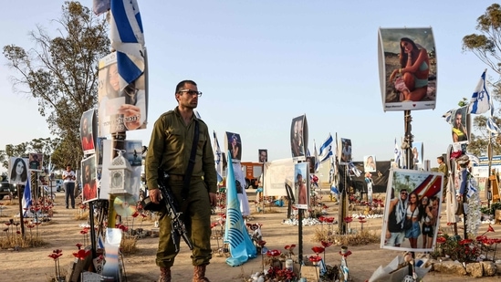 An Israeli soldier visits a memorial bearing portraits of people taken hostage or killed in the Hamas attack on the Supernova music festival on October 7, at the site of the festival near Kibbutz Reim in southern Israel, on May 9, 2024. (Photo by AHMAD GHARABLI / AFP) (AFP)