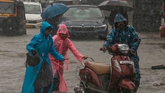 Children push their father's scooter through a flooded street as it rains in Mumbai, India, Thursday, July 25, 2024. (AP)