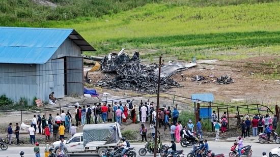 People look at the wreckage of a Saurya Airlines aircraft, a day after it crashed during take off at Tribhuvan International Airport in Kathmandu on July 25, 2024. (Photo by Prabin RANABHAT / AFP)(AFP)