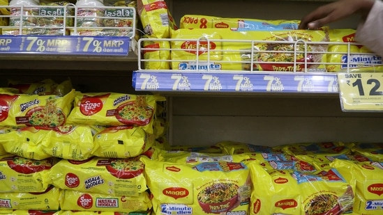 A worker arranges packets of Nestle's Maggi noodles on a shelf inside a supermarket in Mumbai, India.(Reuters)