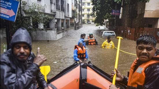 Officials during a rescue operation at a waterlogged area during rain. (PTI)