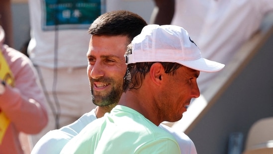 Serbia's Novak Djokovic hugs Spain's Rafael Nadal during a practice session.(REUTERS)