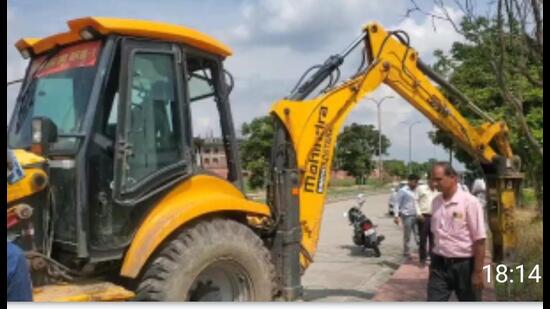 The teams arrived on the university campus along with a heavy force in the afternoon and began erecting poles of cement for demarcating the land to complete the process of confiscation. (HT photo)